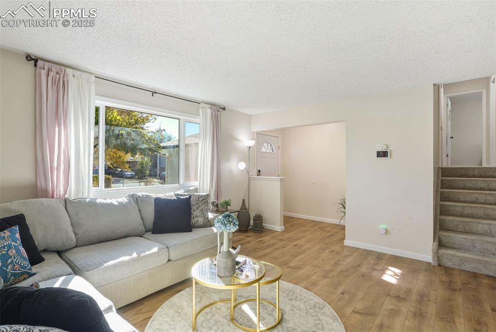 Image 7 of 34: Living area with a coat closet, stairs, and wood finished floors