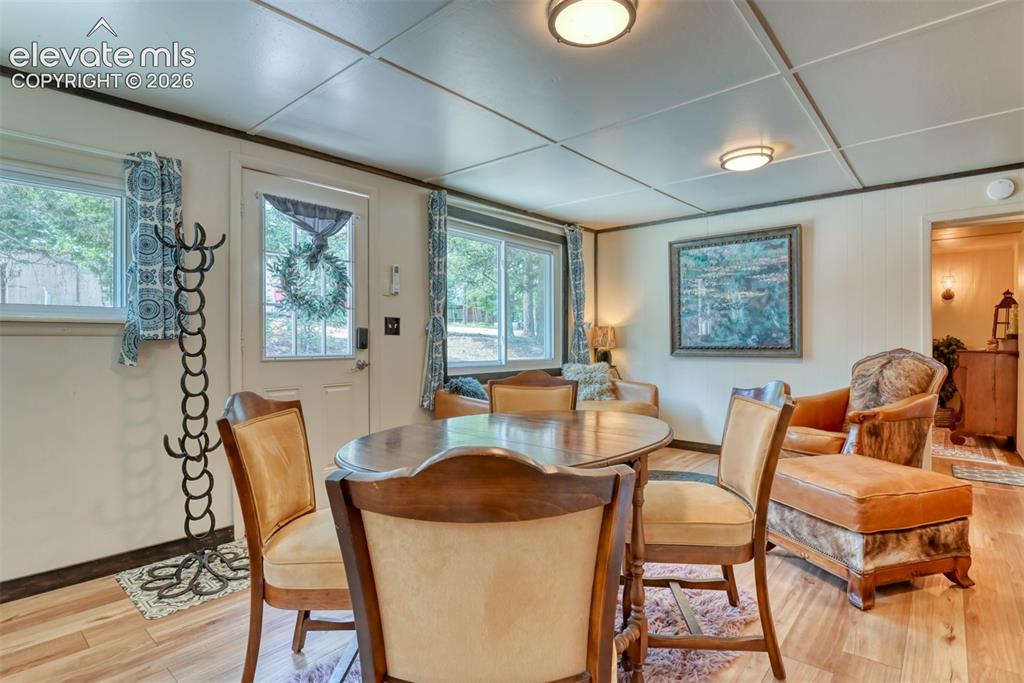 Image 10 of 47: Living area featuring wood-finish flooring, white paneled walls, and a rece