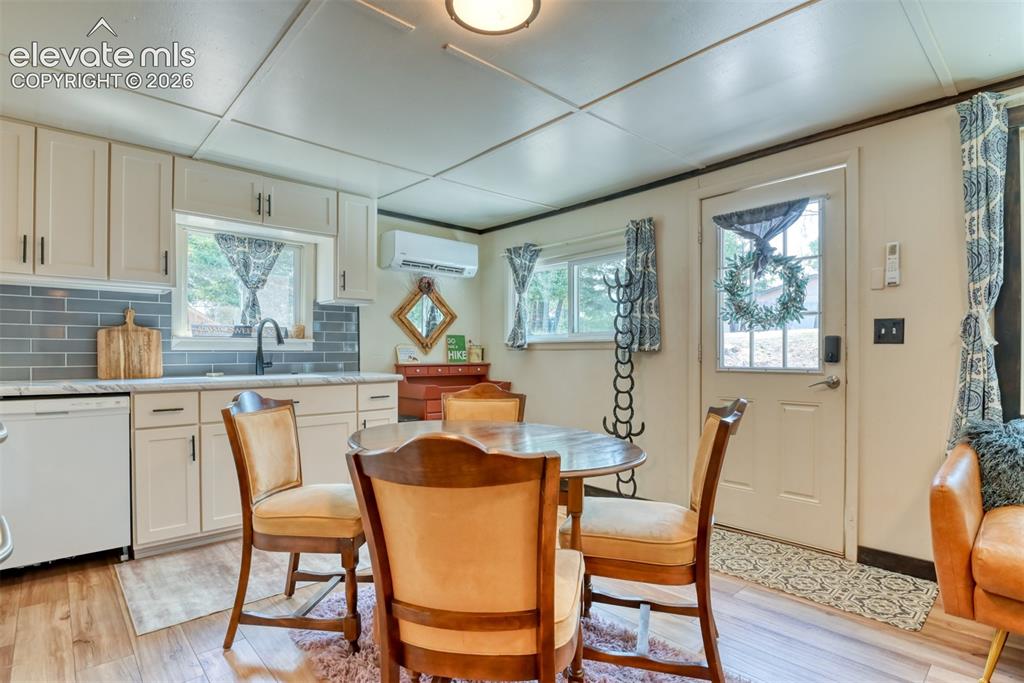 Image 11 of 47: Kitchen area featuring light-toned cabinetry with dark hardware, a subway t