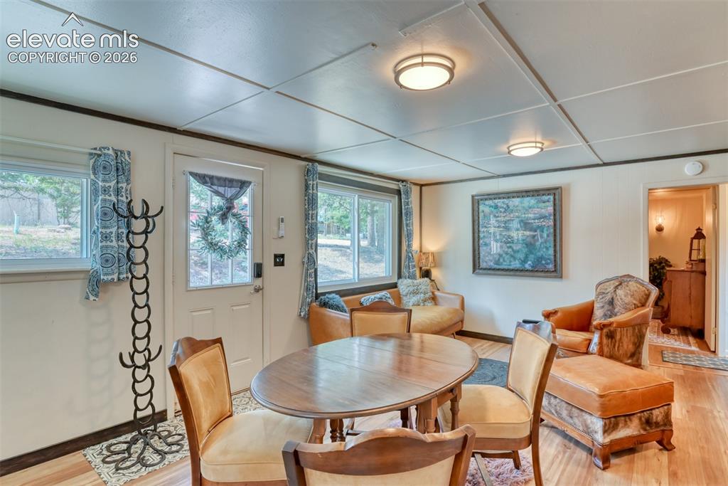 Image 13 of 47: Living space featuring wood-finish flooring, multiple windows providing nat