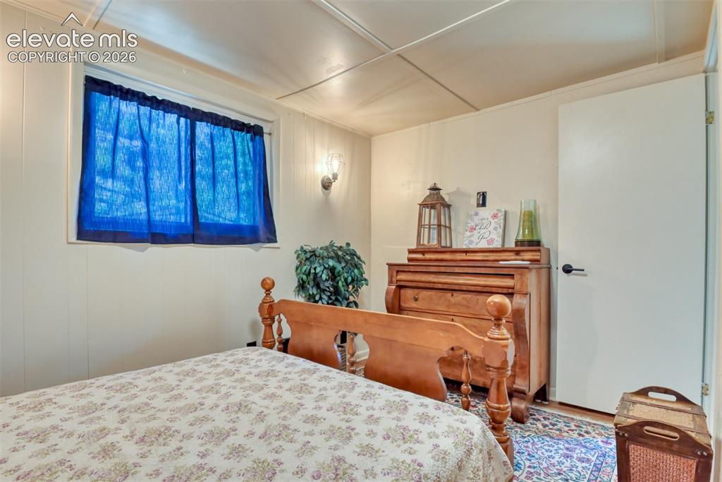 Image 23 of 47: Recessed window with blue sheer curtains, white paneled walls, ceiling pane