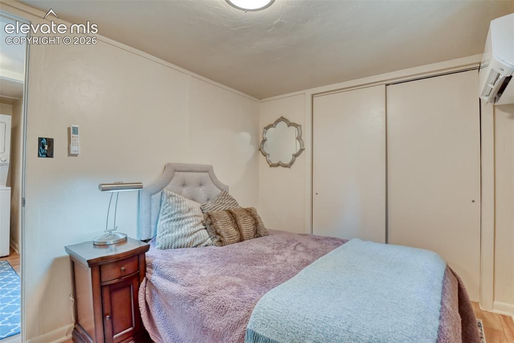 Image 27 of 47: Bedroom featuring wood-finish flooring and a built-in closet with sliding d