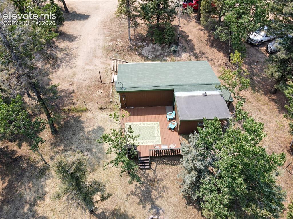 Image 46 of 47: Aerial perspective of a detached dwelling with a green shingle roof, brown