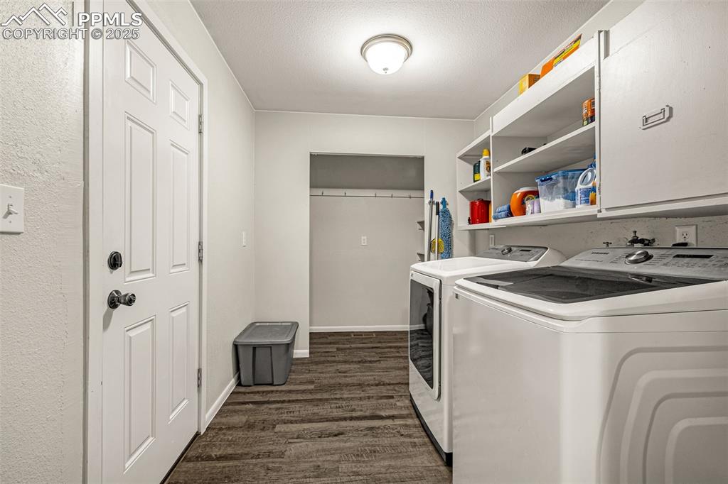 Image 11 of 37: Laundry room with a textured ceiling, dark wood-type flooring, and washer a