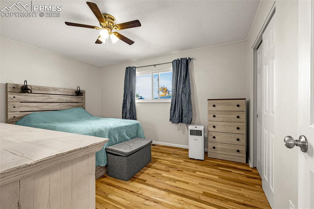 Image 14 of 37: Bedroom featuring light wood finished floors, a textured ceiling, ceiling f