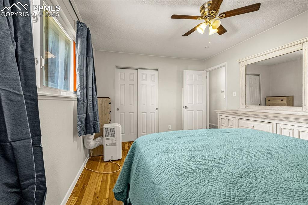 Image 15 of 37: Bedroom featuring wood finished floors, a ceiling fan, a closet, and a text