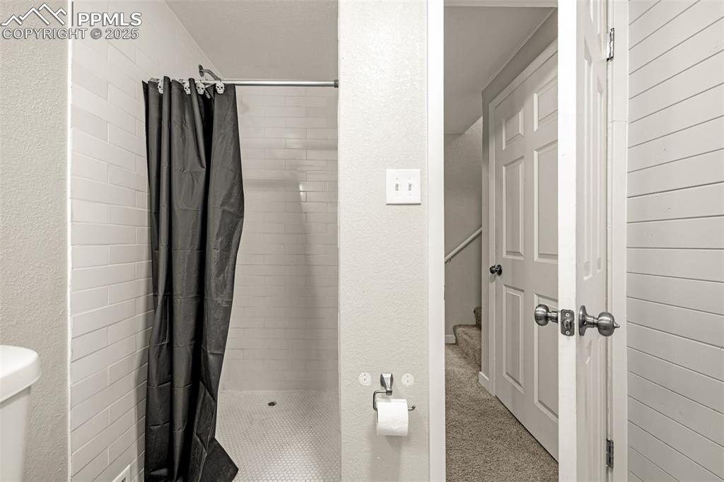 Image 21 of 37: Full bathroom featuring a textured wall and a stall shower
