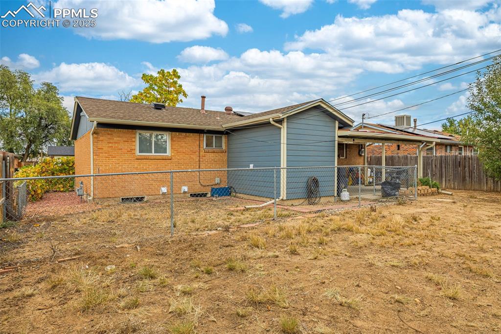 Image 24 of 37: Rear view of property with a fenced backyard, brick siding, and a shingled