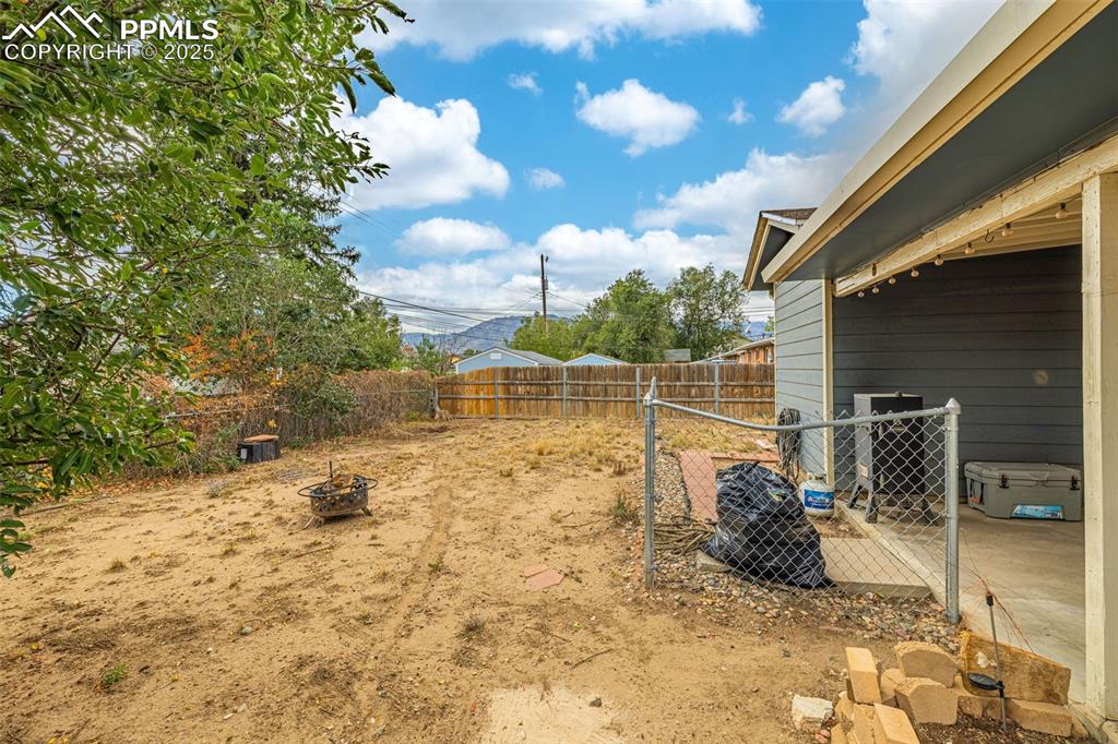 Image 26 of 37: Fenced backyard featuring an outdoor fire pit and a patio area