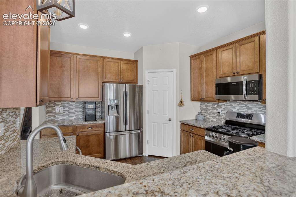 Image 14 of 31: Granite counters & tile backsplash