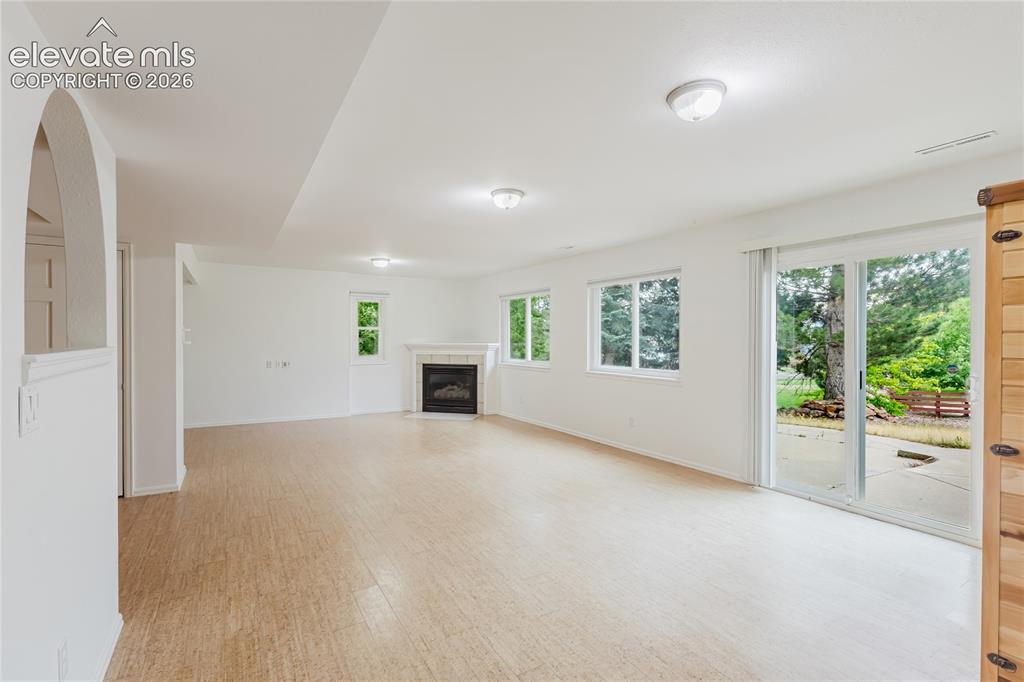 Image 21 of 34: Versatile basement with plenty of light and gas fireplace