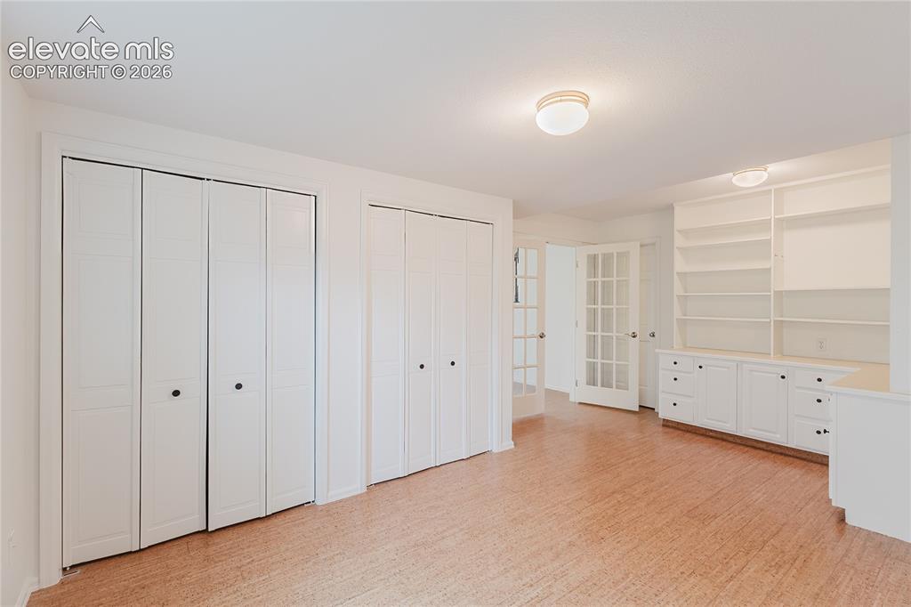Image 24 of 34: Perfect office or library in basement with closets, built-in shelving, and