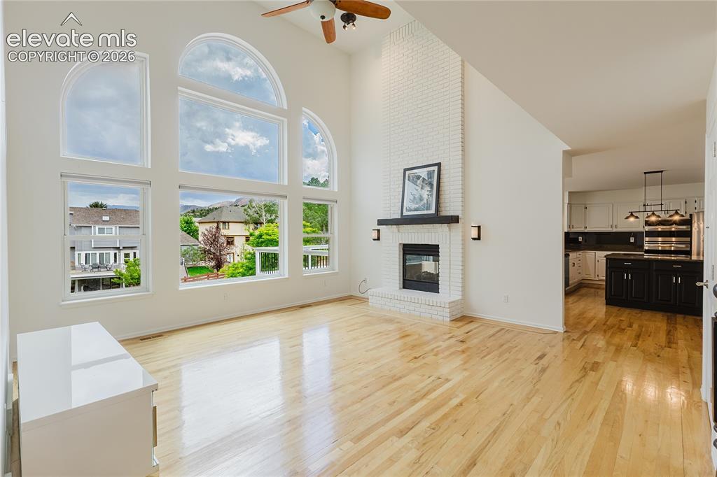 Image 4 of 34: Grand room with tall windows, double sided fireplace, and great entertainin