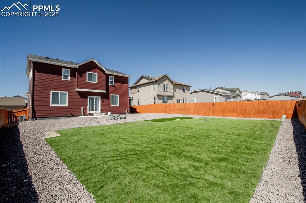 Image 25 of 25: Back of house with a fenced backyard
