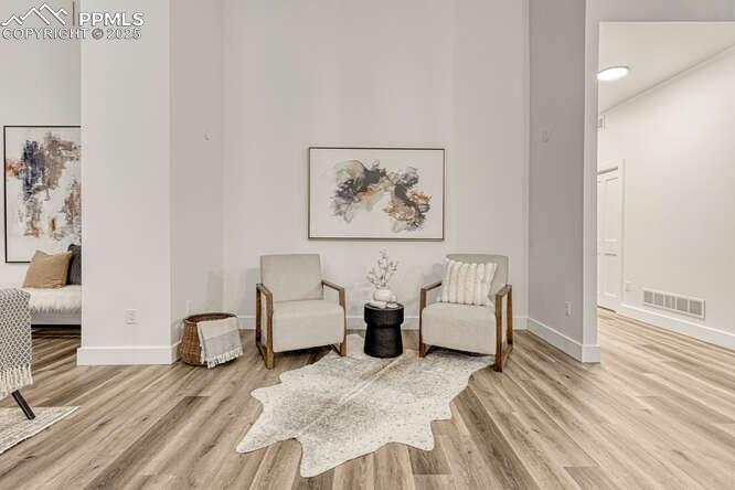 Image 18 of 26: Sitting room with wood finished floors