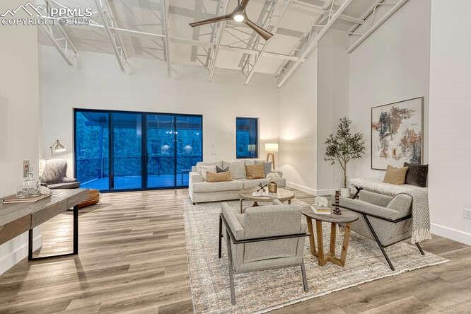 Image 19 of 26: Living room with a towering ceiling and wood finished floors