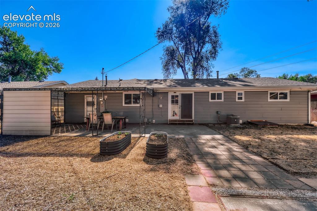 Image 16 of 20: Large backyard with firepit, swing and covered patio area
