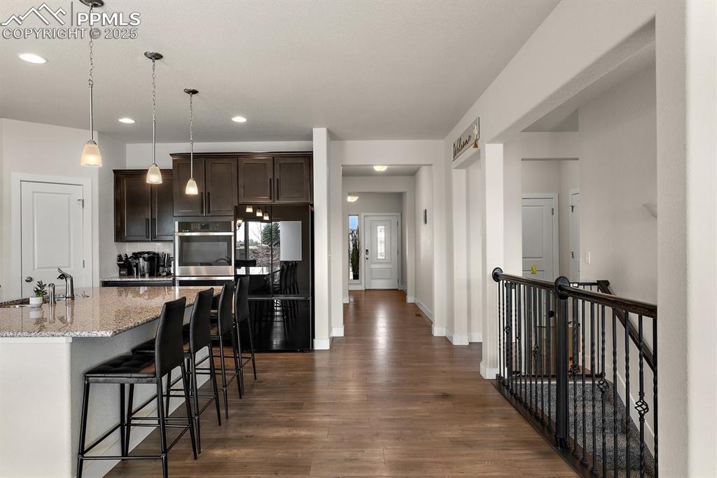 Image 13 of 46: Kitchen featuring dark wood-style floors, a sink, dark brown cabinets, free