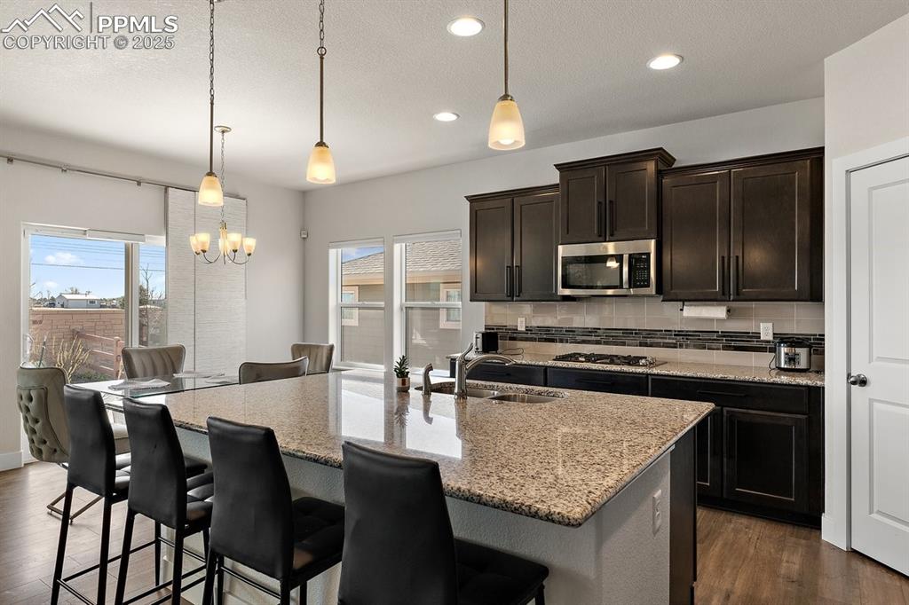 Image 14 of 46: Kitchen featuring a sink, dark wood-type flooring, decorative backsplash, a