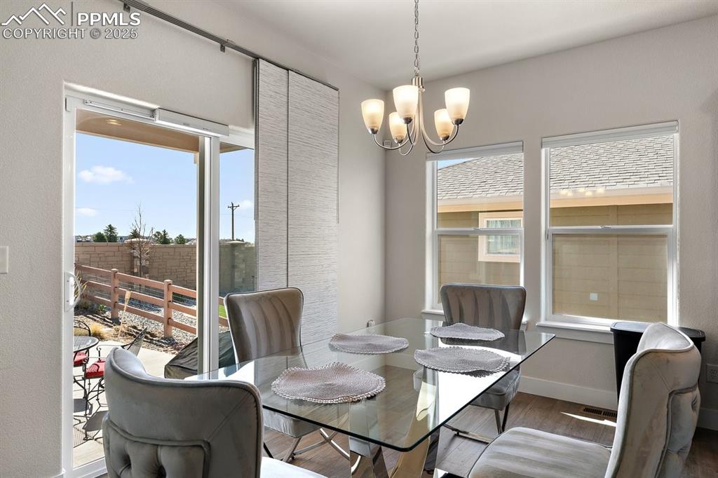 Image 18 of 46: Dining room featuring baseboards, a notable chandelier, and wood finished f