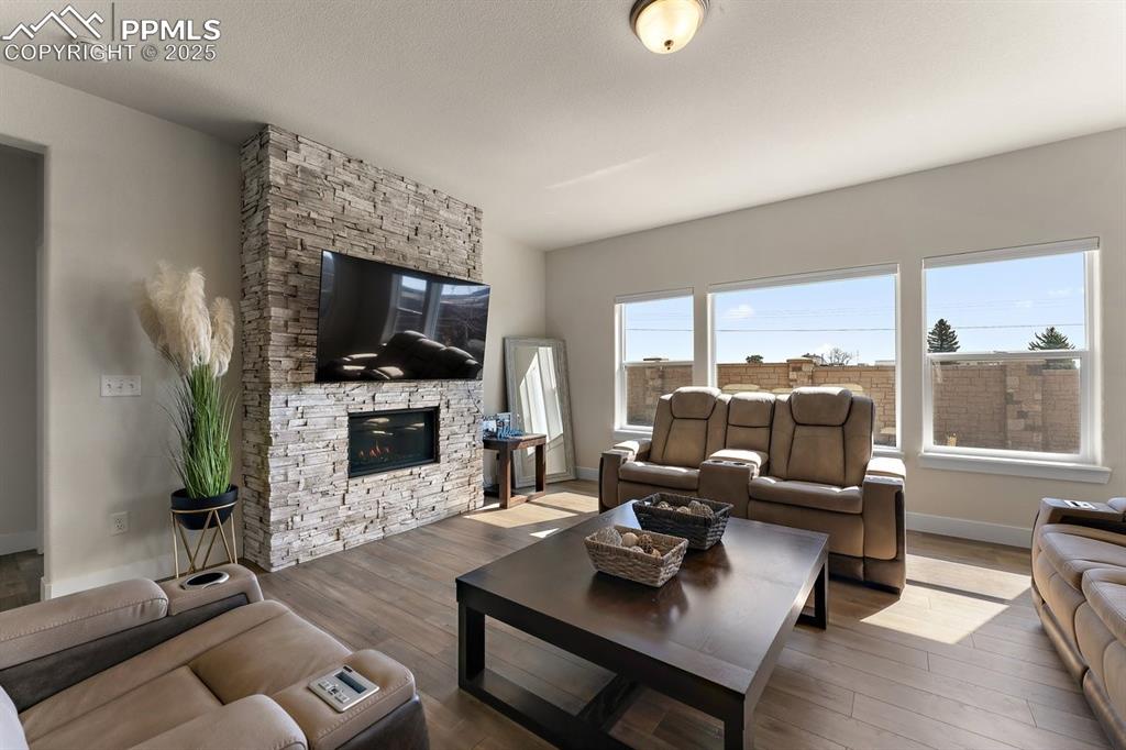 Image 21 of 46: Living room featuring baseboards, wood finished floors, and a fireplace