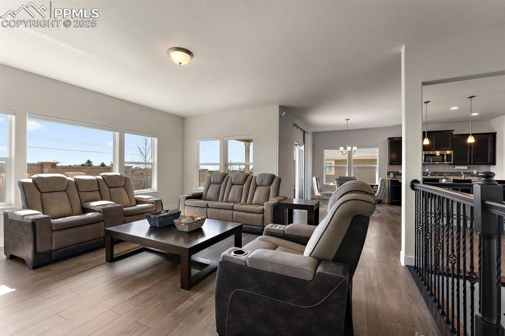 Image 23 of 46: Living area with a notable chandelier and wood finished floors