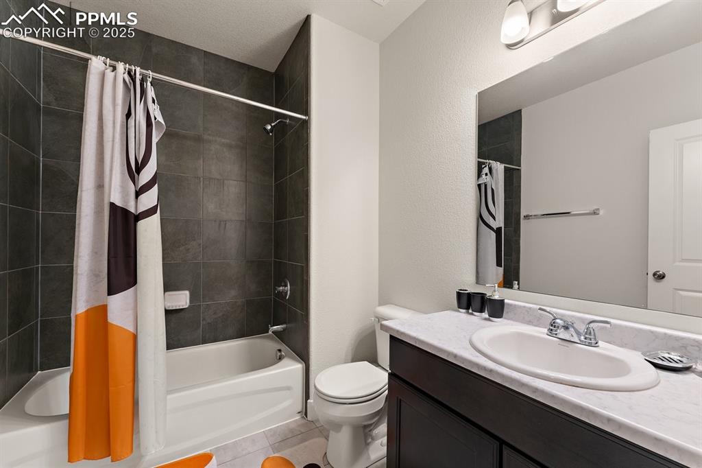Image 25 of 46: Bathroom featuring shower / tub combo with curtain, vanity, and toilet