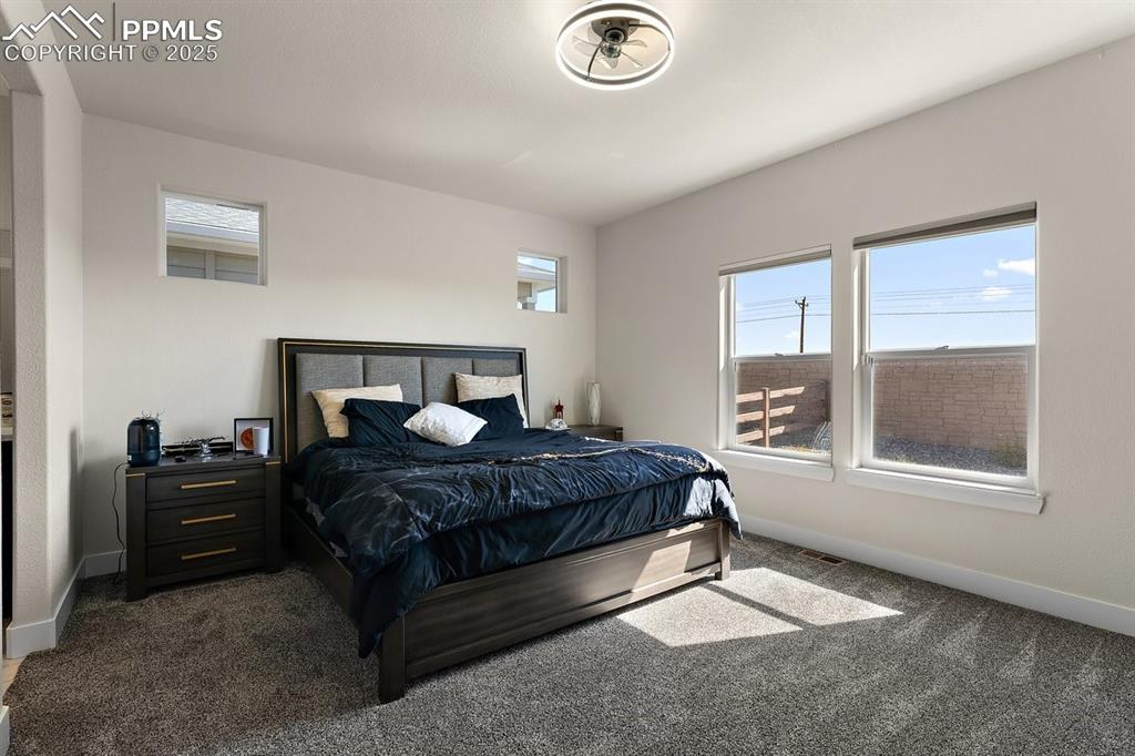 Image 28 of 46: Bedroom featuring visible vents, dark colored carpet, and baseboards