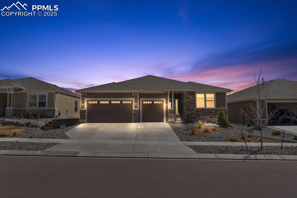 Image 3 of 46: Single story home with an attached garage, driveway, and stone siding
