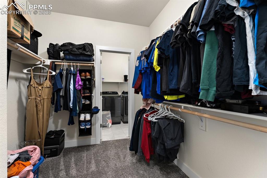 Image 32 of 46: Walk in closet with tile patterned flooring, carpet, and independent washer