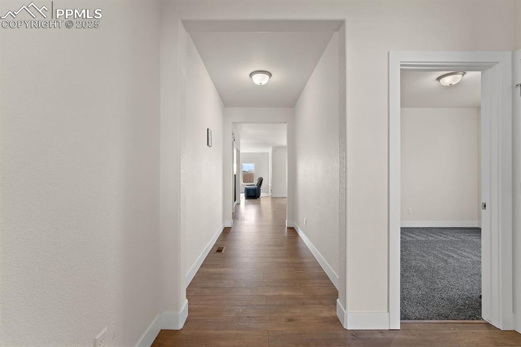 Image 7 of 46: Hallway featuring baseboards and wood finished floors