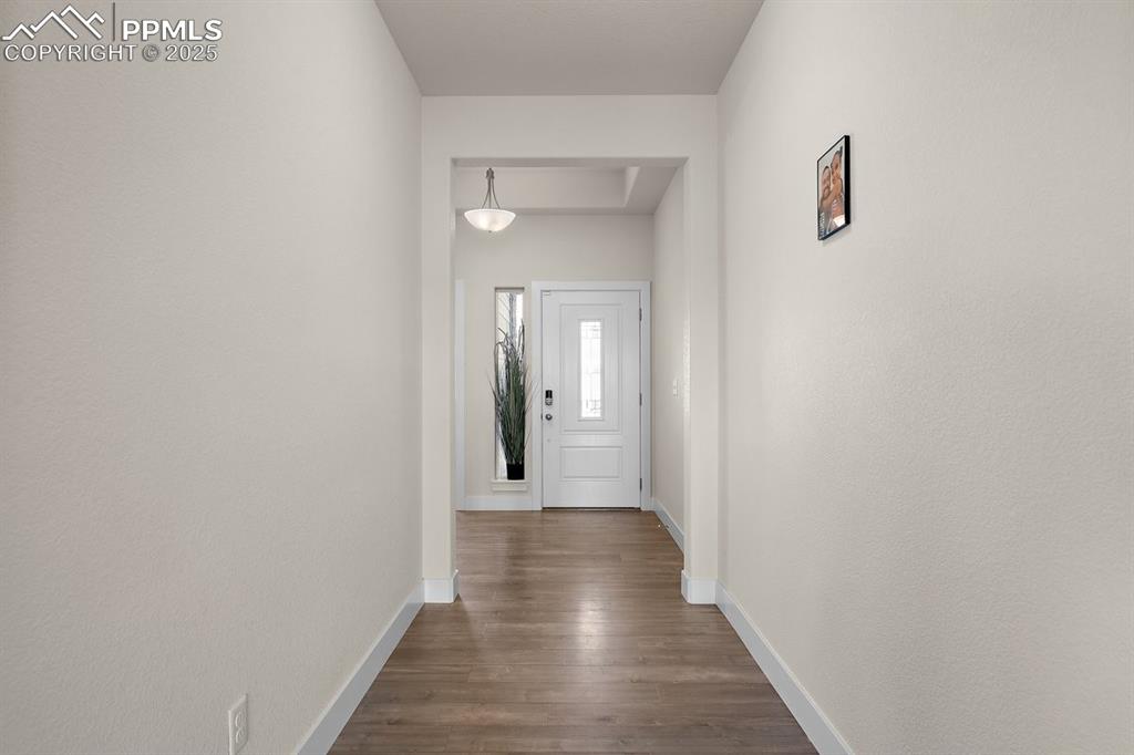 Image 9 of 46: Corridor featuring baseboards and dark wood-style floors