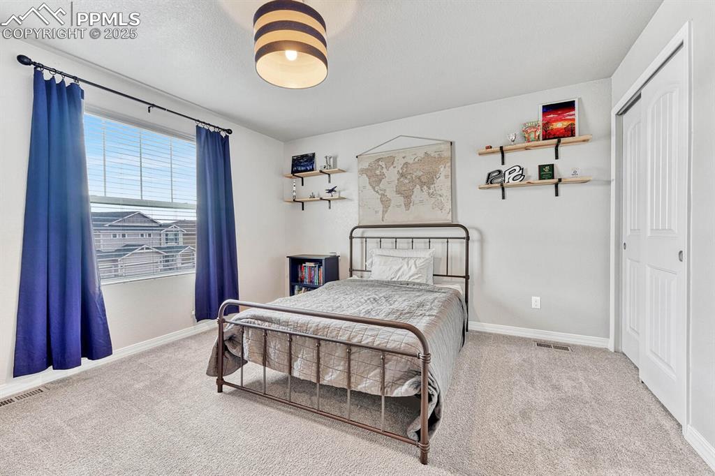 Image 20 of 44: Bedroom featuring a textured ceiling, carpet, visible vents, and baseboards