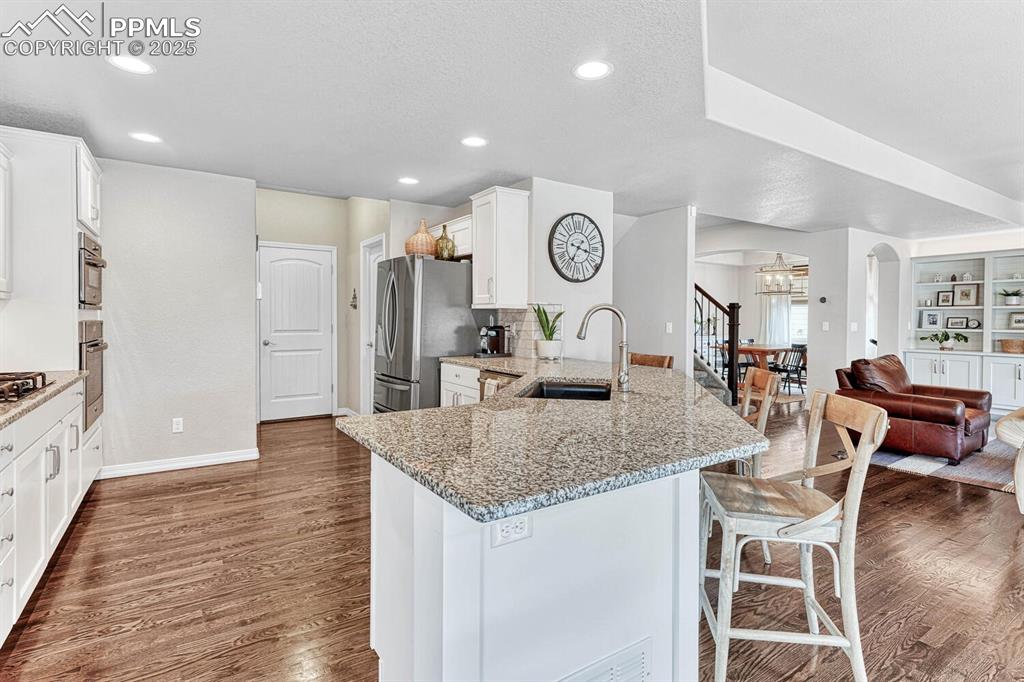 Image 24 of 44: Kitchen with a sink, a peninsula, stainless steel refrigerator with ice dis