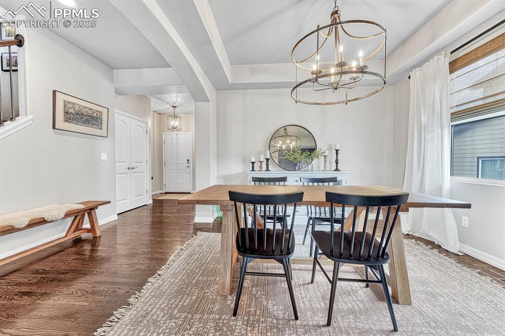 Image 5 of 44: Dining room with wood finished floors, baseboards, an inviting chandelier, 