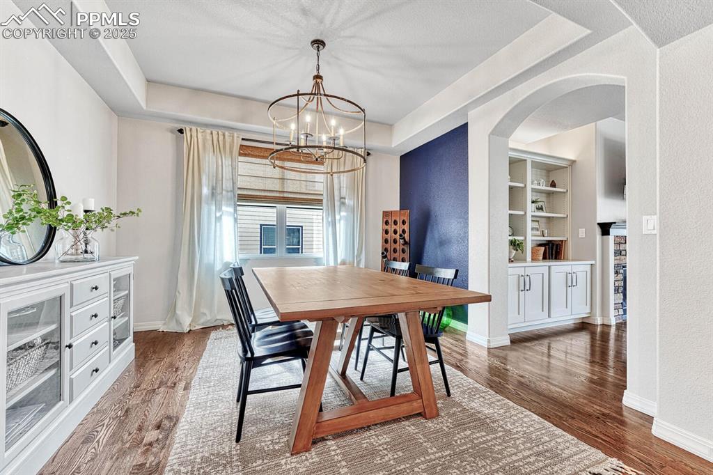 Image 6 of 44: Dining space with built in features, baseboards, and wood finished floors