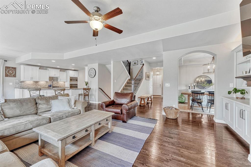 Image 9 of 44: Living room featuring stairs, recessed lighting, ceiling fan with notable c