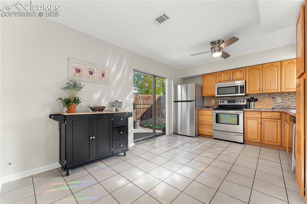 Image 8 of 33: Moveable island with storage available to remain, slider to back yard