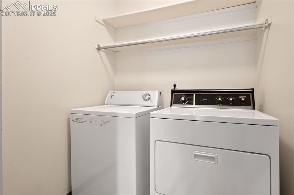 Image 21 of 23: Separate laundry room includes washer and dryer plus shelving and storage c