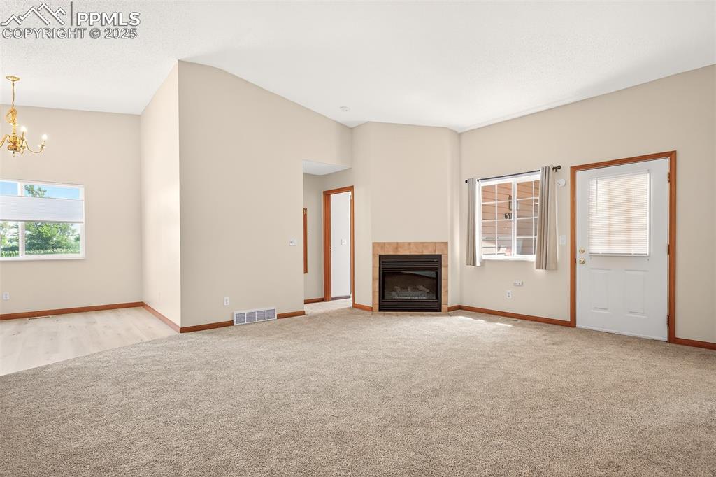 Image 6 of 23: Inviting living room with vaulted ceiling, new carpet and gas fireplace wit