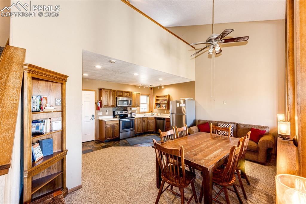 Image 10 of 42: Dining area featuring a towering ceiling, ceiling fan, recessed lighting, d