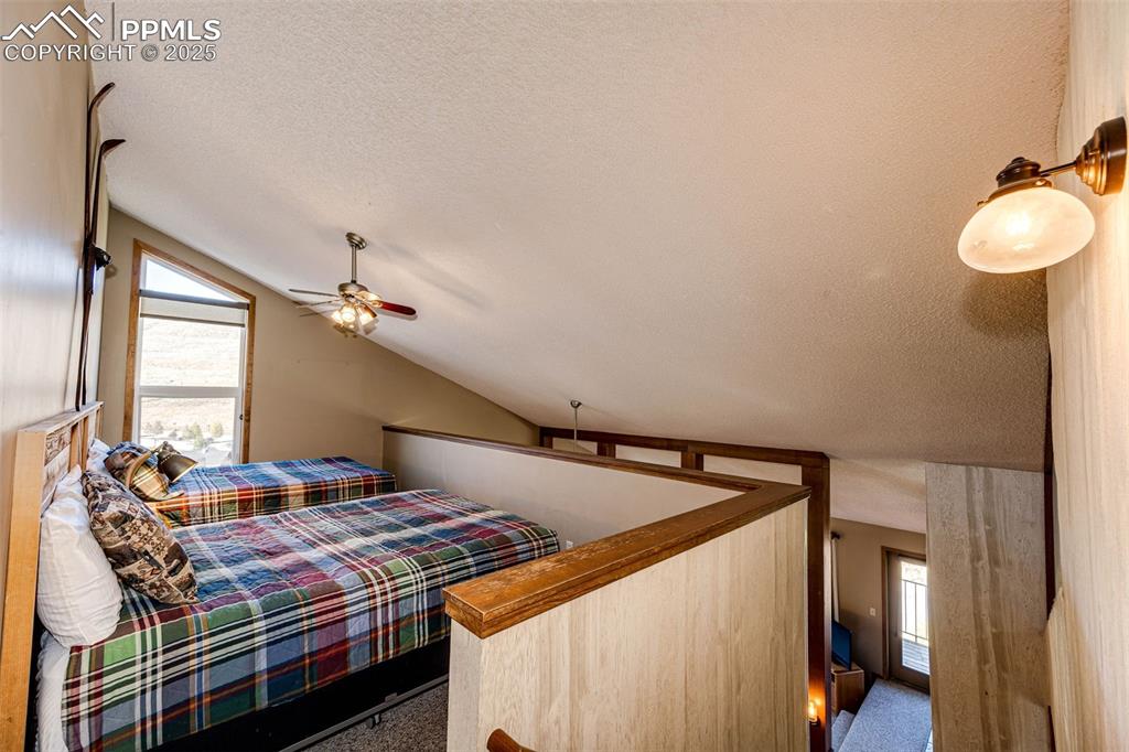 Image 24 of 42: Bedroom featuring vaulted ceiling and a textured ceiling