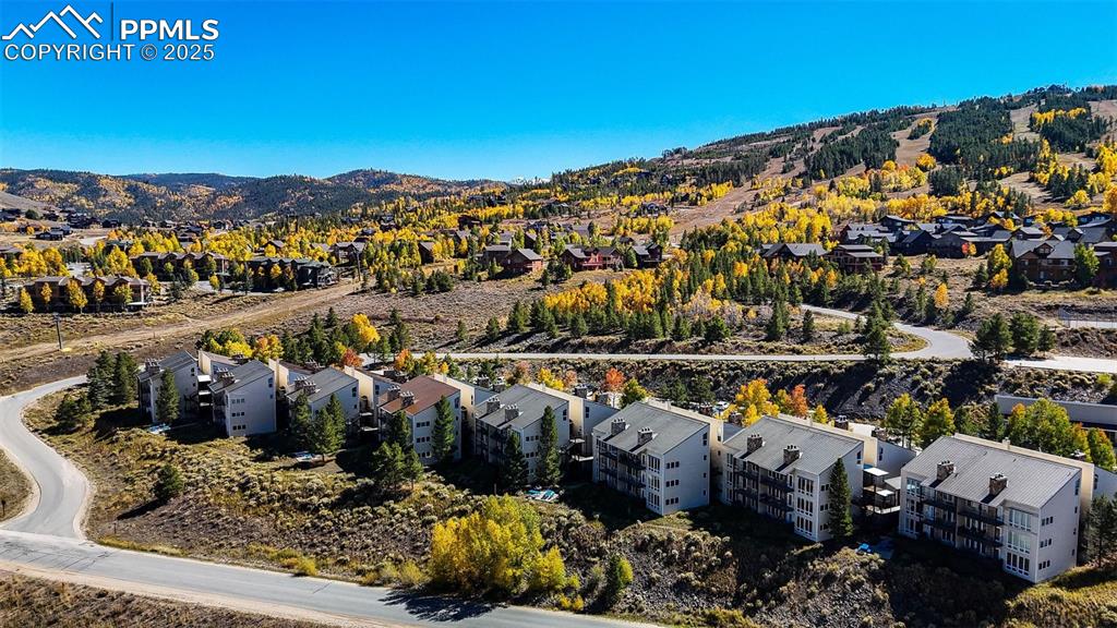 Image 32 of 42: Aerial view of residential area featuring a mountain backdrop