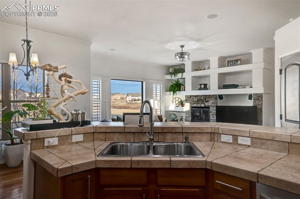 Image 17 of 50: Sink overlooking the dining room and living room. To the right is a second 