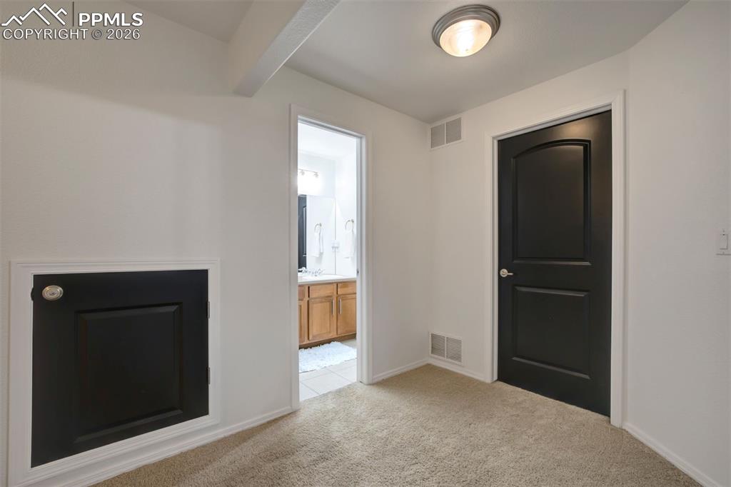 Image 39 of 50: Locked storage under the stairs. Door to utility room