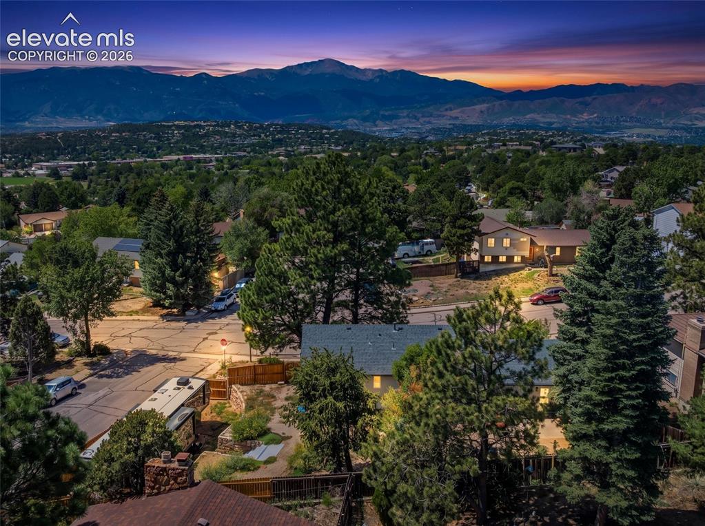 Image 5 of 30: Expansive mountain backdrop with a residential neighborhood featuring matur