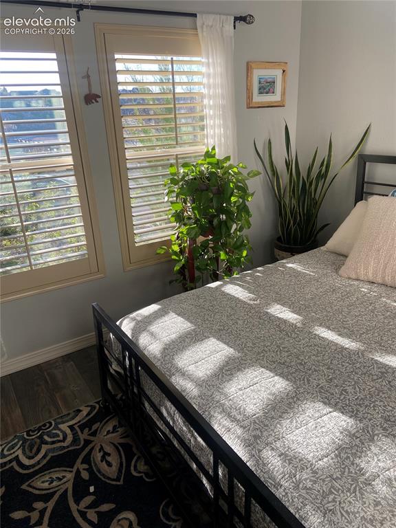 Image 42 of 49: Plantation shutters, wood-finish flooring, and white baseboards