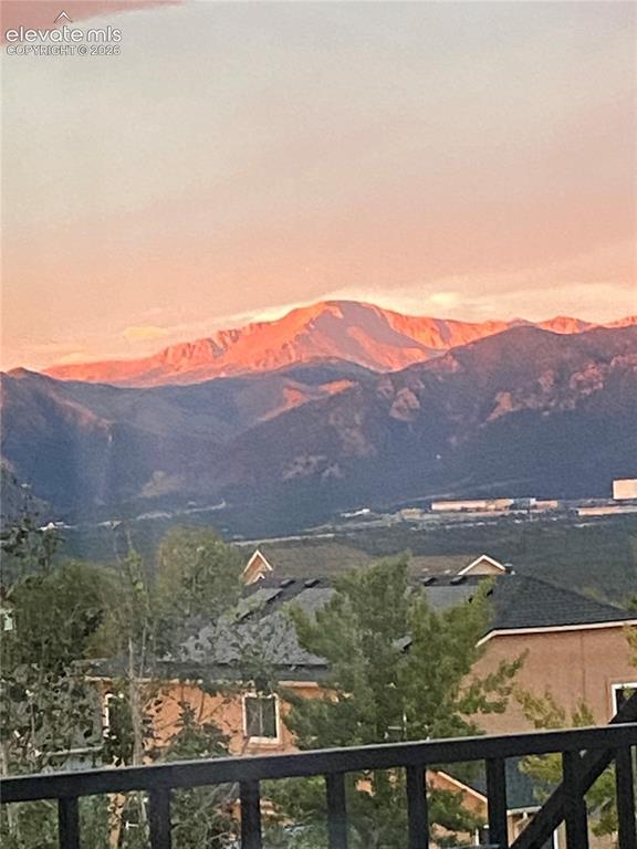Image 47 of 49: Distant mountain range with a prominent peak under a soft, colored sky