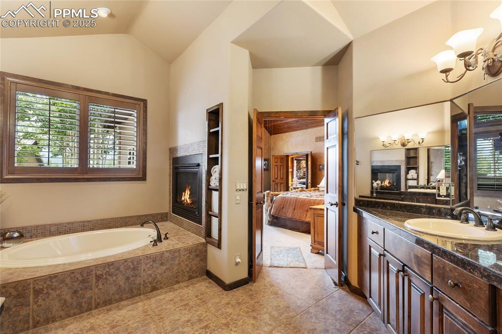 Image 20 of 46: Large soaking tub and dual sided fireplace in the main Primary