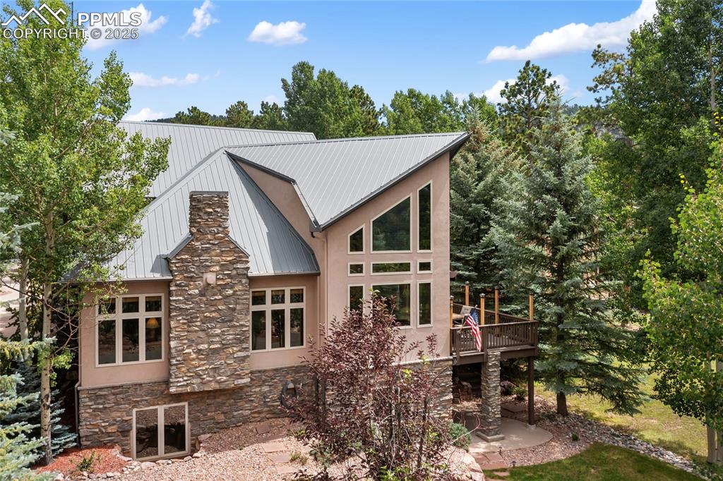 Image 5 of 46: Stacked stone, stucco, metal roof and loads of windows!